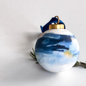 Serene hand-painted ceramic ornament hanging with ribbon